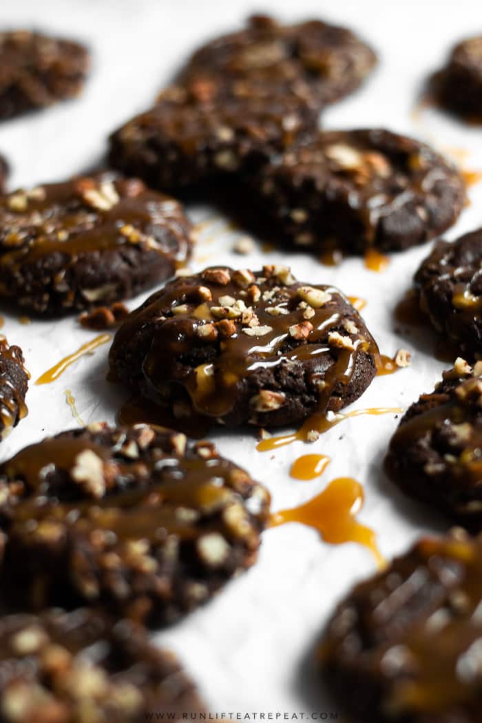 Fudgy brownie-like cookies rolled in pecans and topped with a drizzle of homemade caramel.Â #cookies #chocolate #pecans #brownie #christmas