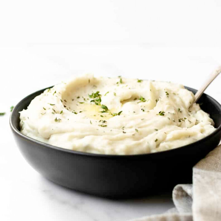 The best creamy slow cooker mashed potatoes infused with garlic and herbs. This recipe comes together seamlessly in the slow cooker. I make this simple Thanksgiving side dish every year and it's a guest favorite!