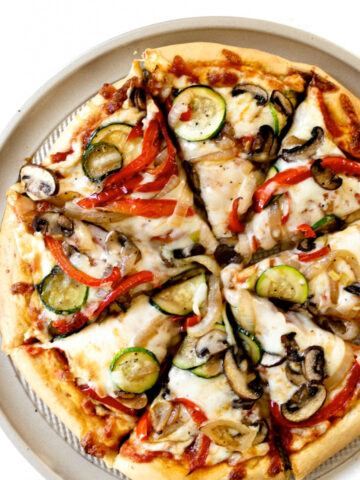 This homemade vegetable pizza is made on a simple pizza crust using a go-to pizza dough recipe that you pile high with your favorite veggies! Skip the pizza delivery because homemade tastes even better!