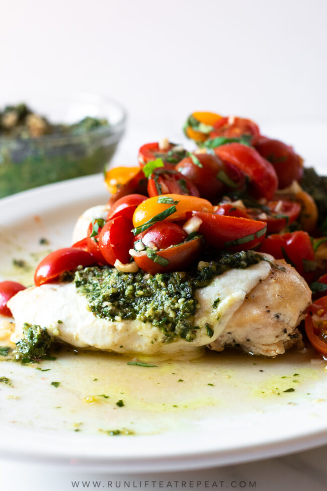This pesto bruschetta chicken is made with simple feel-good ingredients and is on the table in 35 minutes! This recipe has layers of flavors from the pesto, to the bruschetta, to the chicken. It's a rave-worthy recipe that will be on repeat no matter the time of year!