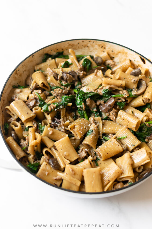This creamy Italian sausage pasta is coated in a light, garlic, cheesy cream sauce and filled with Italian sausage, mushrooms and spinach. It's the one pan recipe that will be your new favorite weeknight dinner.