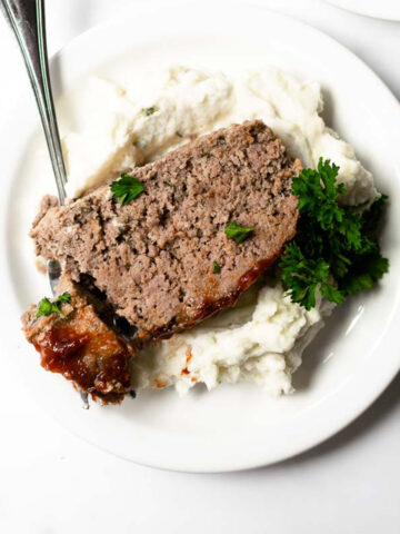 I present to you the best meatloaf recipe— it's tender, juicy, loaded with flavor and topped with unique but delicious glaze. This meatloaf recipe is easy to make and ready in less than an hour! It's a recipe that your entire family with find comfort in.