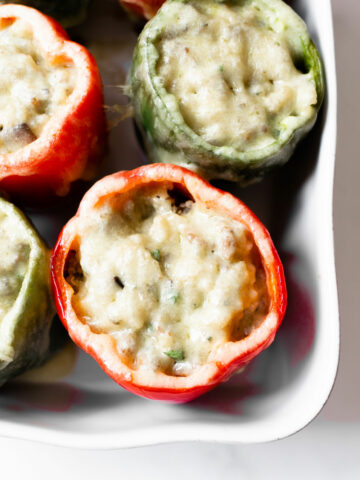 These sausage stuffed peppers are made with ground sausage, onions, mushrooms, garlic, herbs, chicken broth, and quinoa. It's a hearty dinner recipe that the whole family will love!