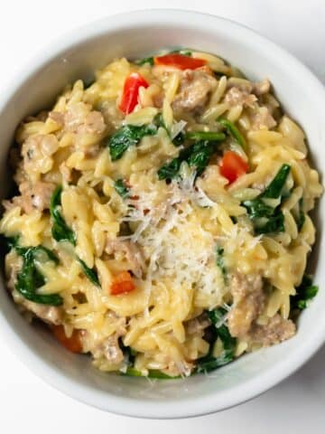 This one pan Italian sausage orzo is a quick and easy meal made with red bell peppers, onions, garlic, orzo, chicken broth, cream, parmesan, and spinach. It's perfect for busy weeknights— minimal effort and minimal clean up!