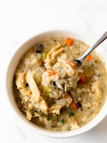 This slow cooker creamy chicken and rice soup is incredibly simple to make. Made with carrots, celery, onions, mushrooms, chicken, rice, variety of spices, and finished off with cream. Pair this with