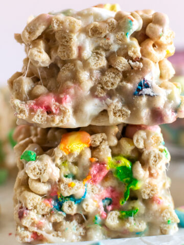 These lucky charms rice krispie treats will make any day magical! Done in 30 minutes and made with just 4 ingredients, this recipe creates the perfect ratio of nostalgic Lucky Charms cereal to marshmallows producing extra gooey fun and festive rice krispie treats!