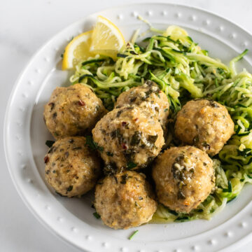 baked chicken meatballs on a plate with zucchini noodles