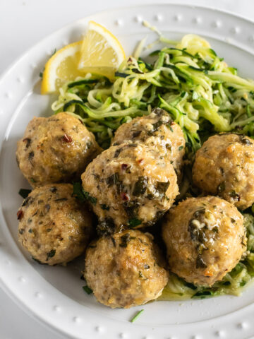 baked chicken meatballs on a plate with zucchini noodles