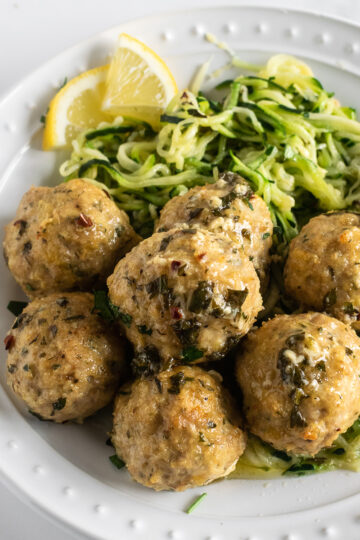 baked chicken meatballs on a plate with zucchini noodles