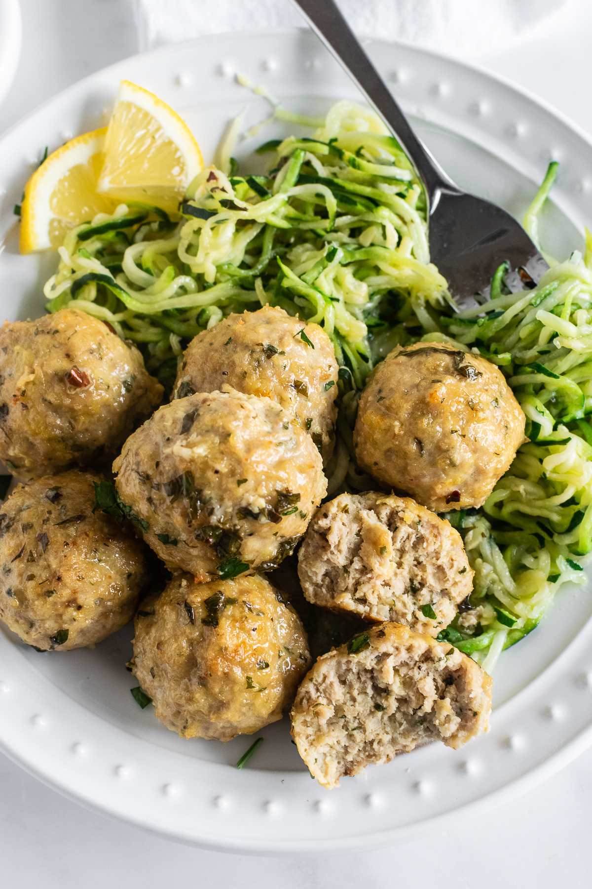 baked chicken meatballs with lemon garlic herb sauce on plate