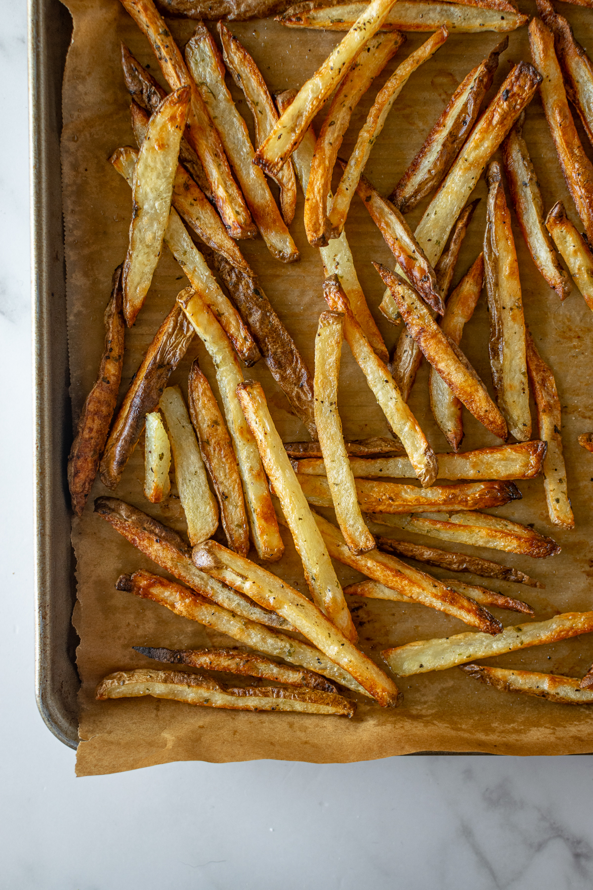 baked french fries on a baking sheet with parchment paper.