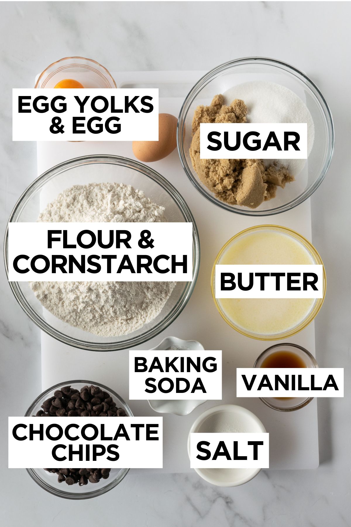 ingredients for chewy chocolate chip cookies such as egg, egg yolks, sugar, flour, cornstarch, butter, baking soda, chocolate, vanilla and salt.