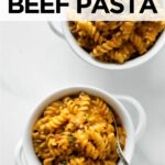 creamy beef pasta in two white bowls with forks.
