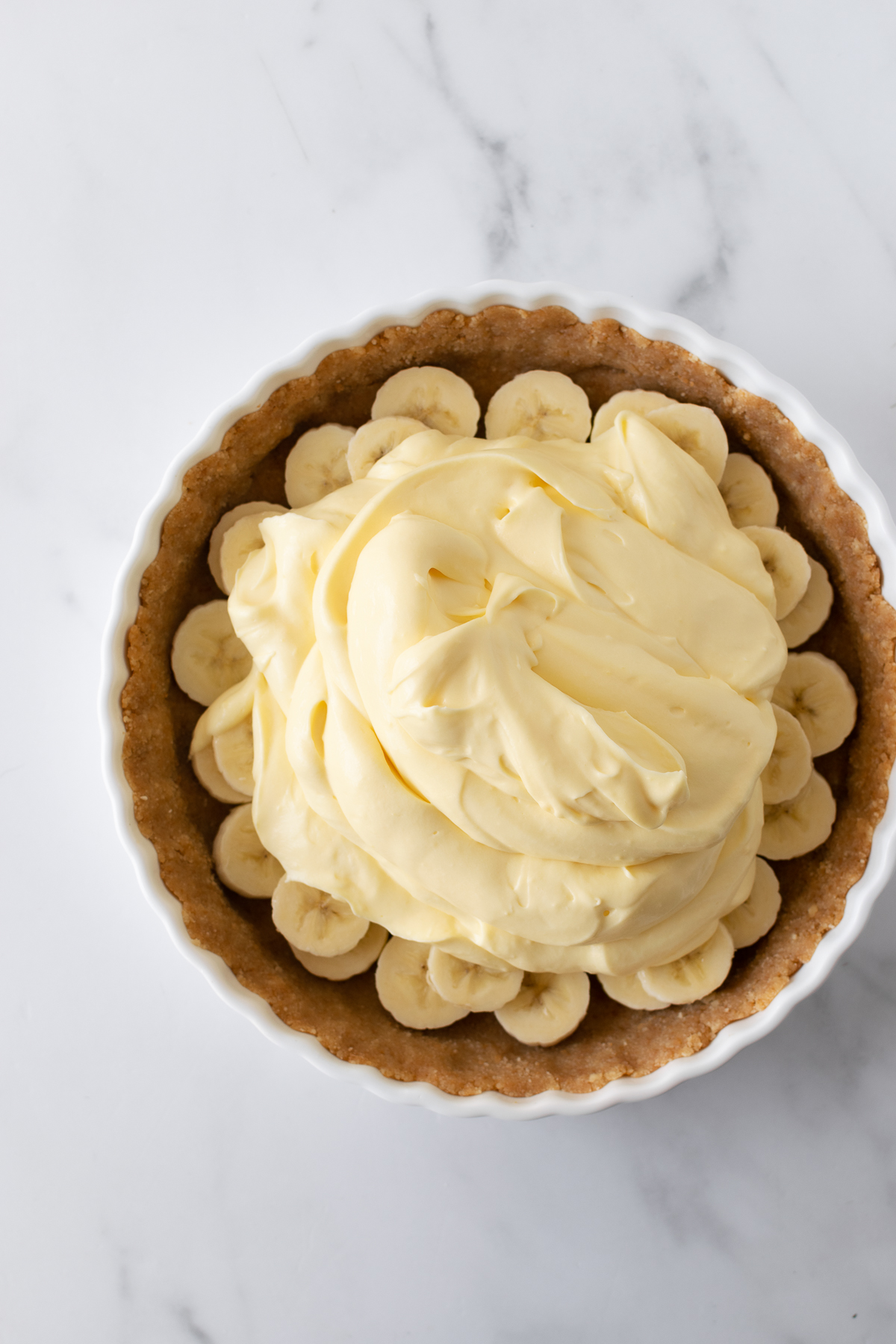 Get ready to fall in love with this no-bake banana pudding pie recipe. It starts with a buttery Nilla Wafer cookie crust, a layer of fresh banana slices and creamy vanilla pudding, and finished with homemade whipped cream. After the first bite you'll immediately know why it's loved by many!