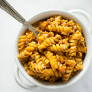 creamy beef pasta in a white bowl with a fork.