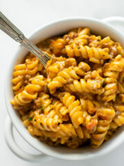 creamy beef pasta in a white bowl with a fork.