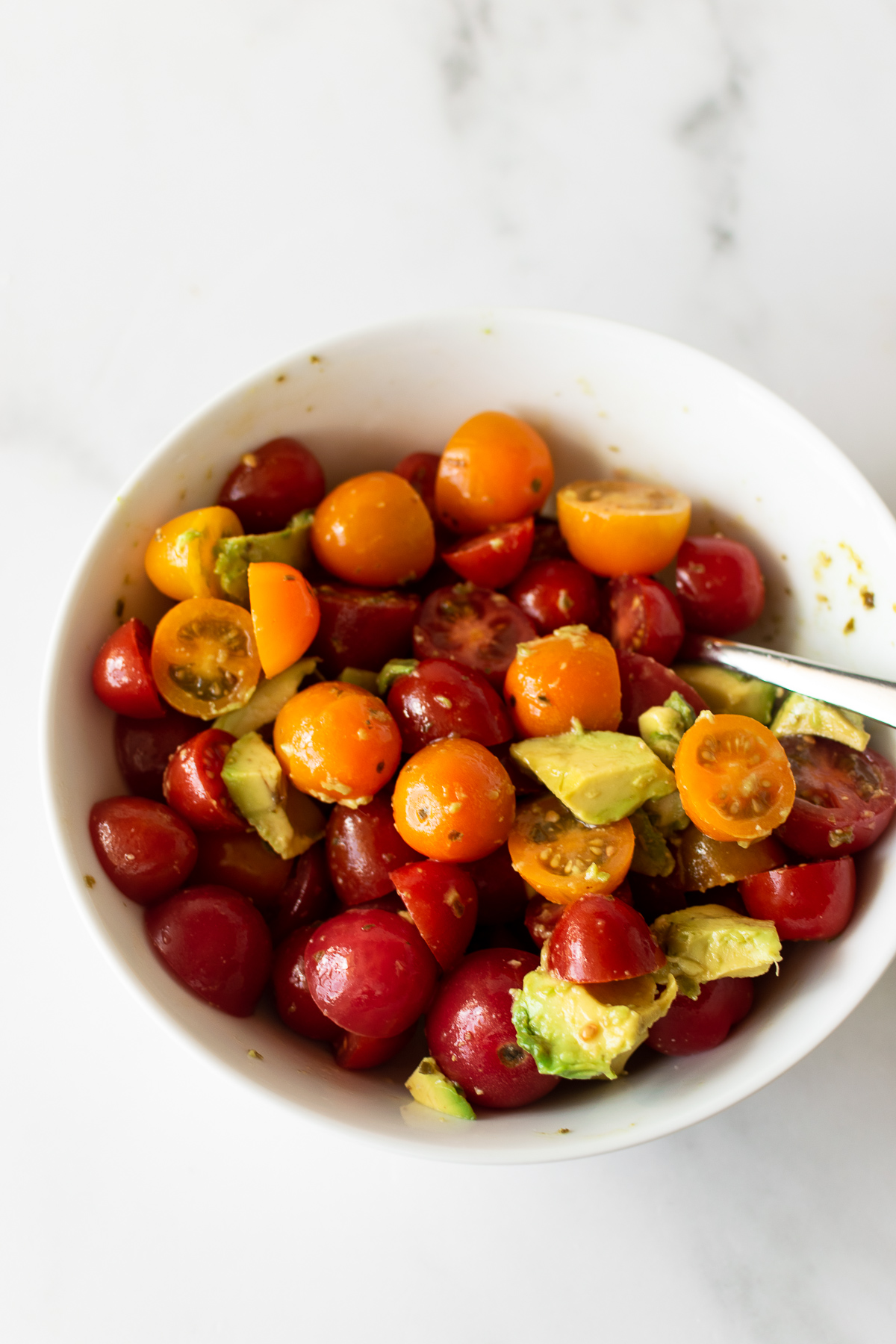 tomatoes and avocado in a white bowl.