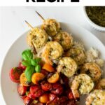 pesto shrimp on skewers with tomatoes in a white bowl.