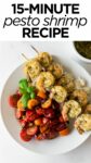 pesto shrimp on skewers with tomatoes in a white bowl.