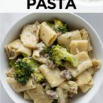 rigatoni pasta with sausage and broccoli with a cream sauce in two white bowls.