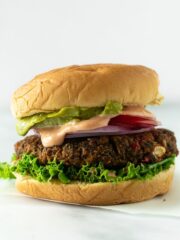 veggie burger topped with lettuce, tomato, onion, special sauce, and guacamole.