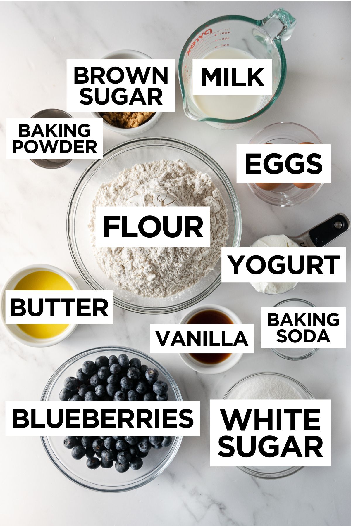 ingredients in bowls for blueberry muffins such as flour, butter, milk, yogurt, etc.