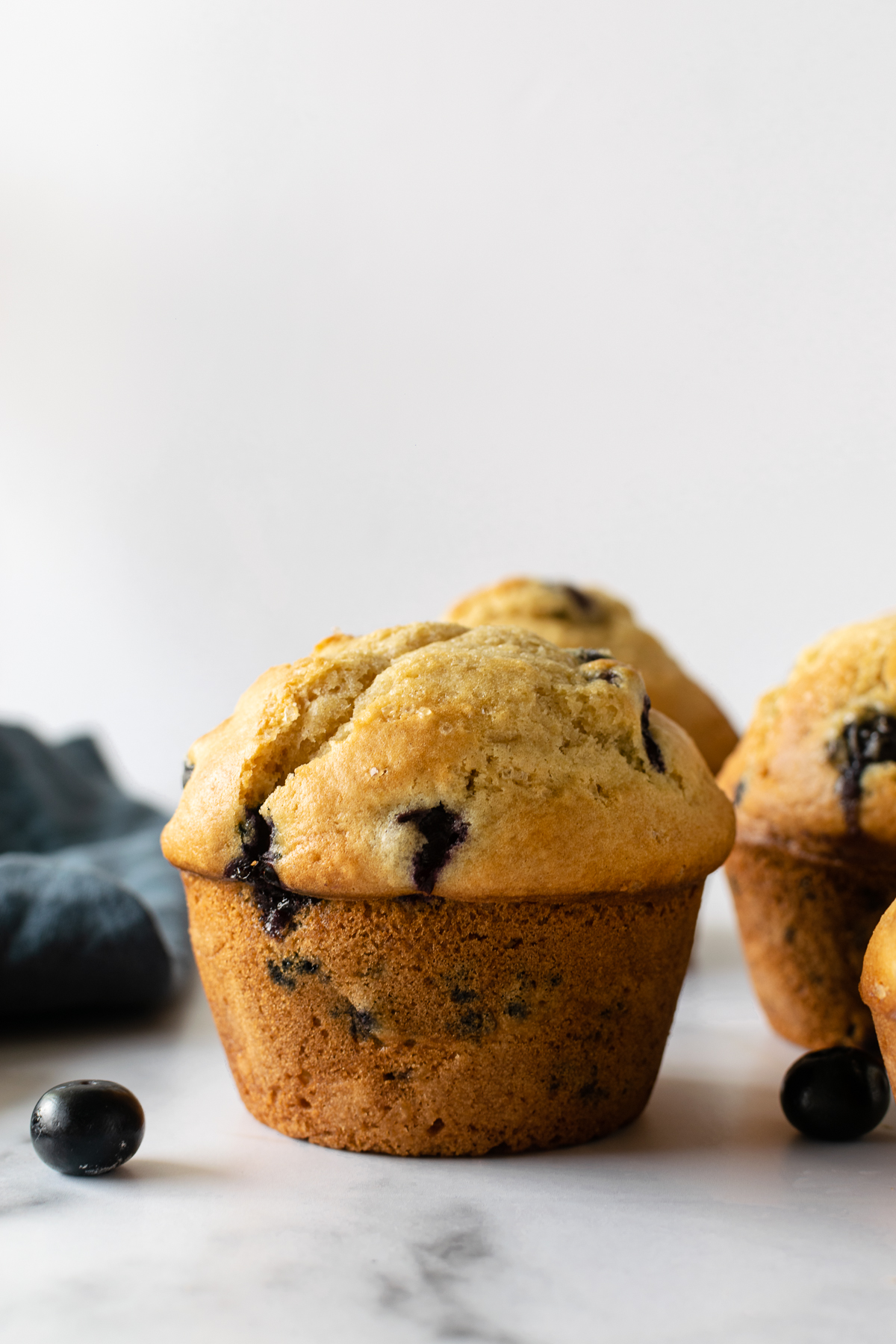 blueberry muffins on a white table.