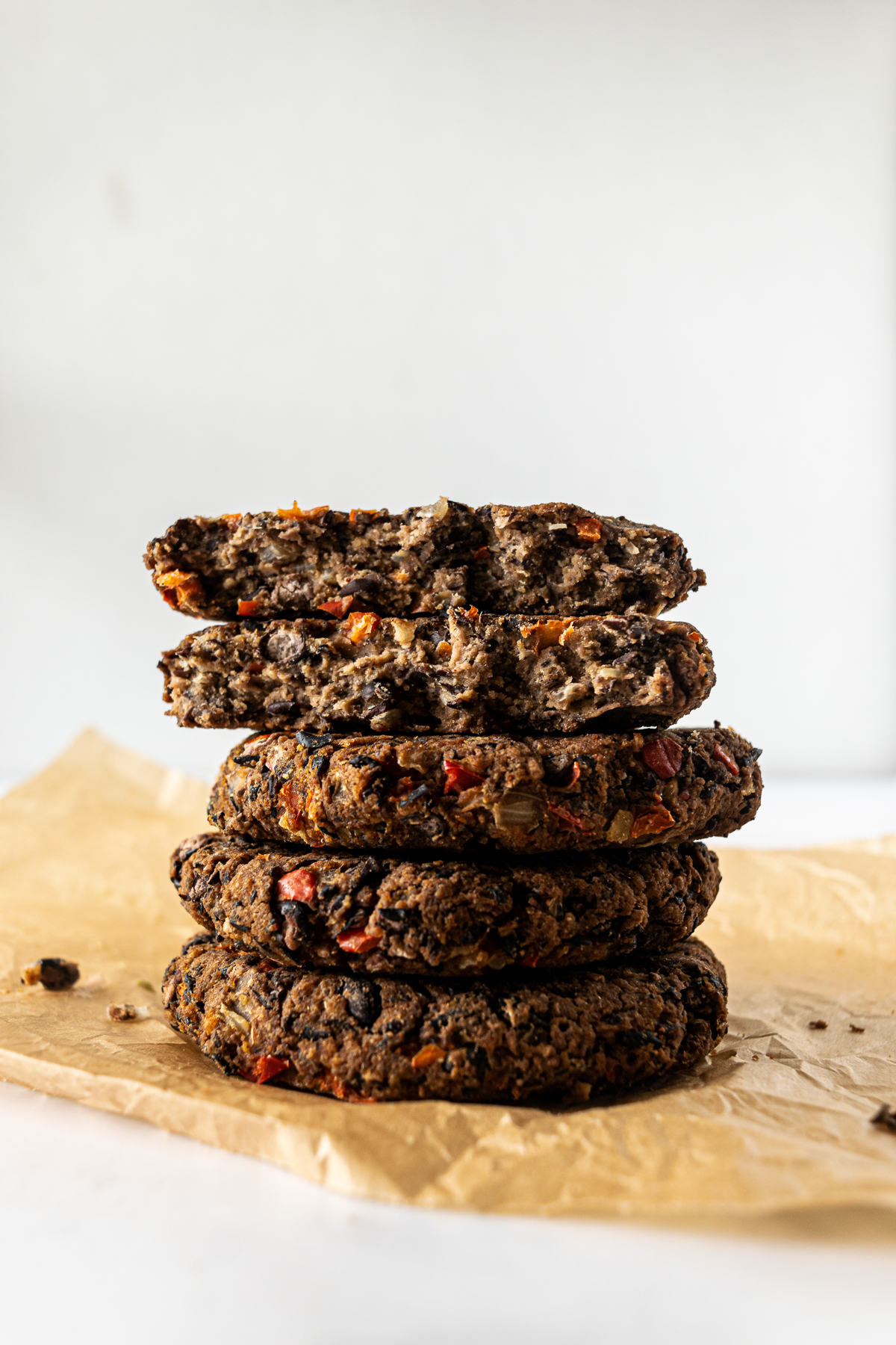 stacked black bean burgers on parchment paper.
