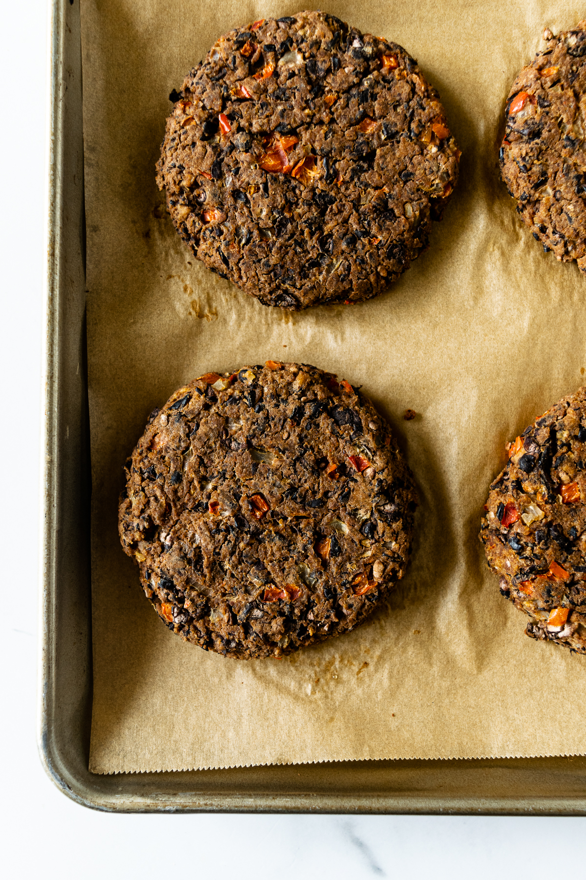 cooked black bean burgers on a baking sheet lined with parchment paper.