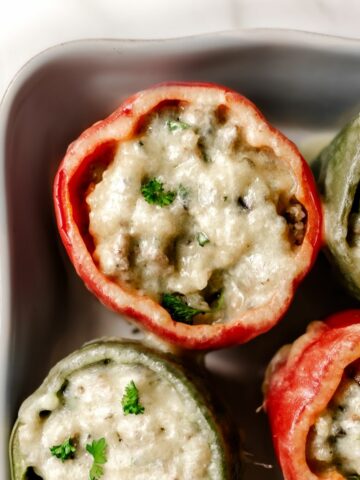 These sausage stuffed peppers are a satisfying twist on classic stuffed peppers and on the table in 35 minutes. The sweet bell peppers are stuffed with a savory blend of sausage, hearty quinoa, garlic, fresh herbs, and topped with cheese.