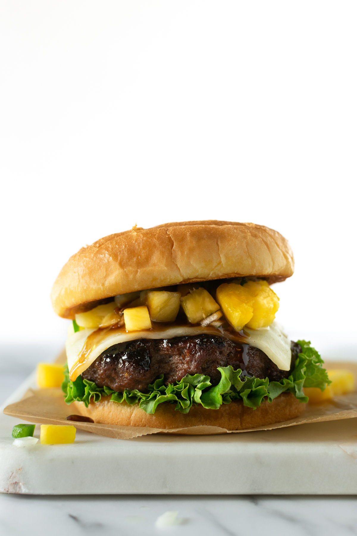 teriyaki burgers with melted cheese, lettuce, and pineapple salsa.