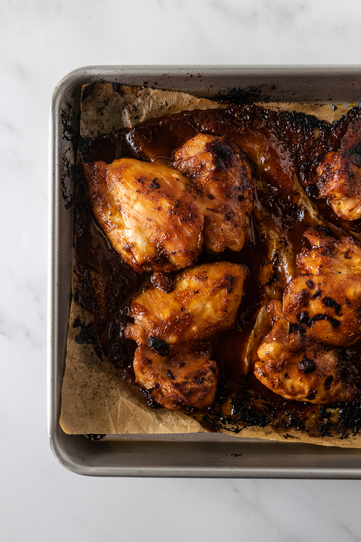 baked bbq chicken thighs on a baking sheet.