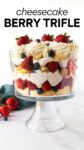 berry trifle in a glass trifle dish with pound cake, cheesecake filling, berries and whipped cream with text overlay.