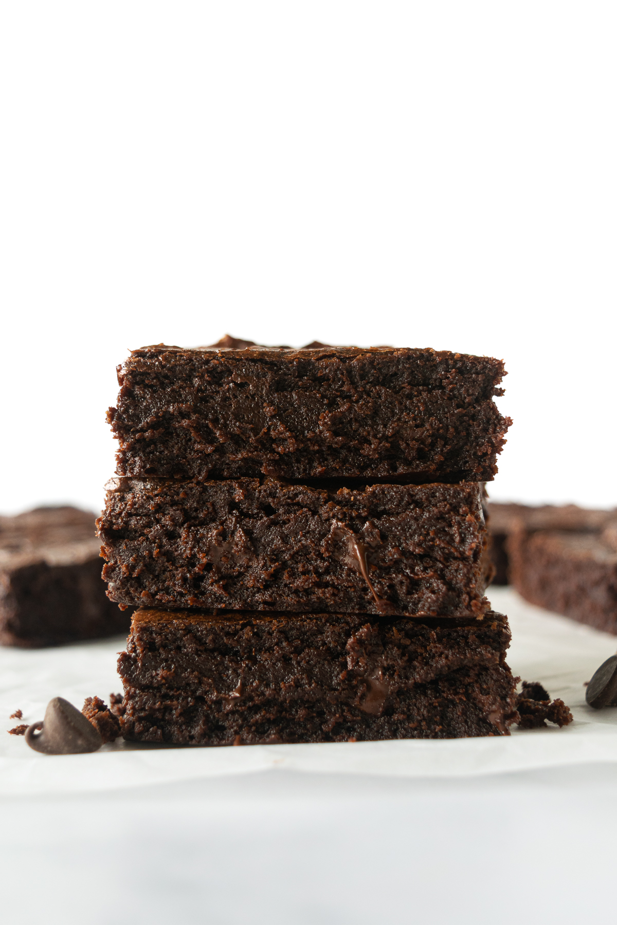 three stacked brownies on a white table.