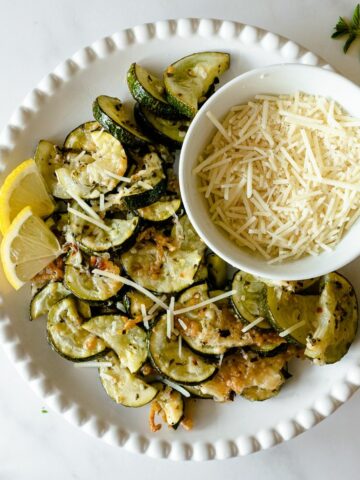 Turn bland zucchini into an ultra-flavorful side dish with this roasted zucchini recipe. Combine fresh lemon and garlic, spices, and parmesan cheese, and bake until tender. Done in 30 minutes– this easy oven roasted zucchini is the answer to enjoying extra zucchini all season long!