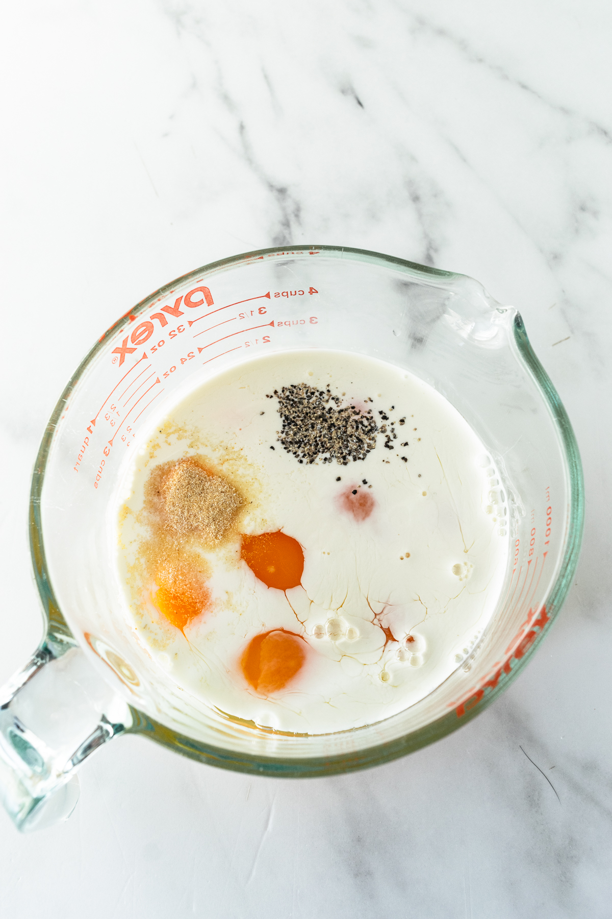 eggs, milk, heavy cream, and spices in a large measuring cup.