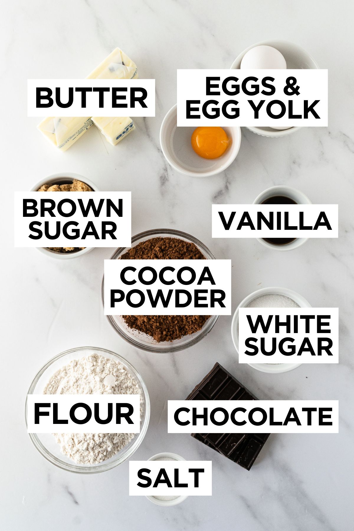 ingredients for homemade brownies in bowls on a white table.