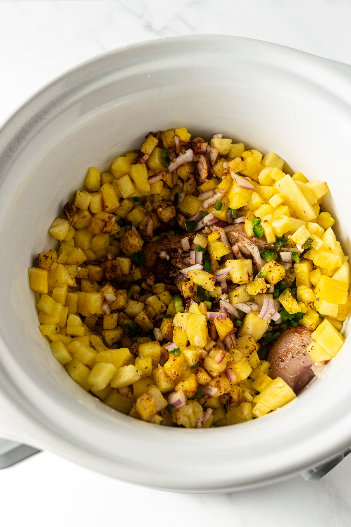 ingredients for pineapple chicken tacos in a slow cooker.