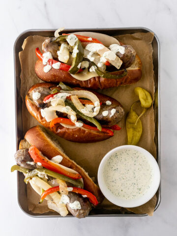 sausage and peppers sandwiches topped with garlic aioli