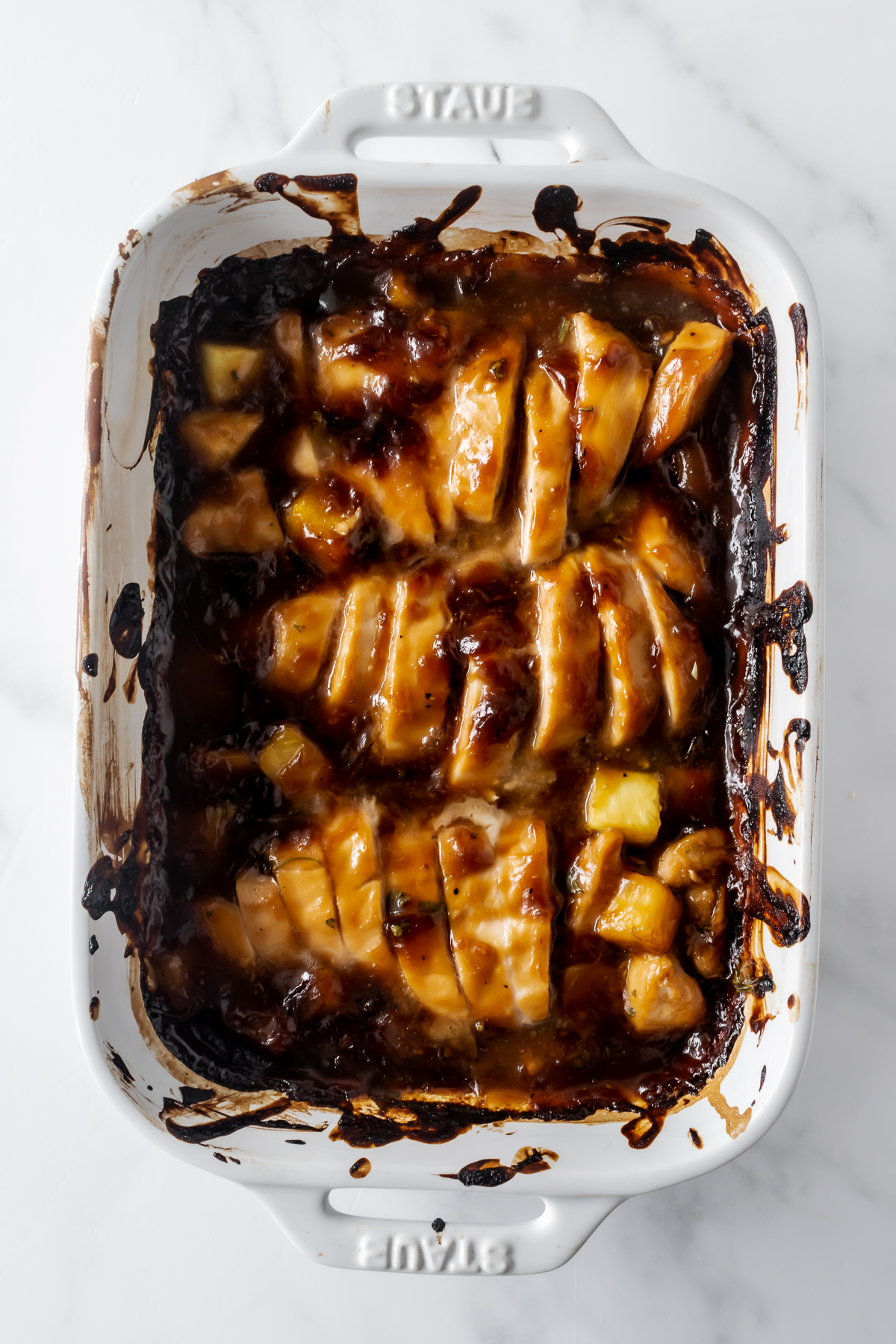 baked chicken teriyaki with pineapple in a white baking dish.