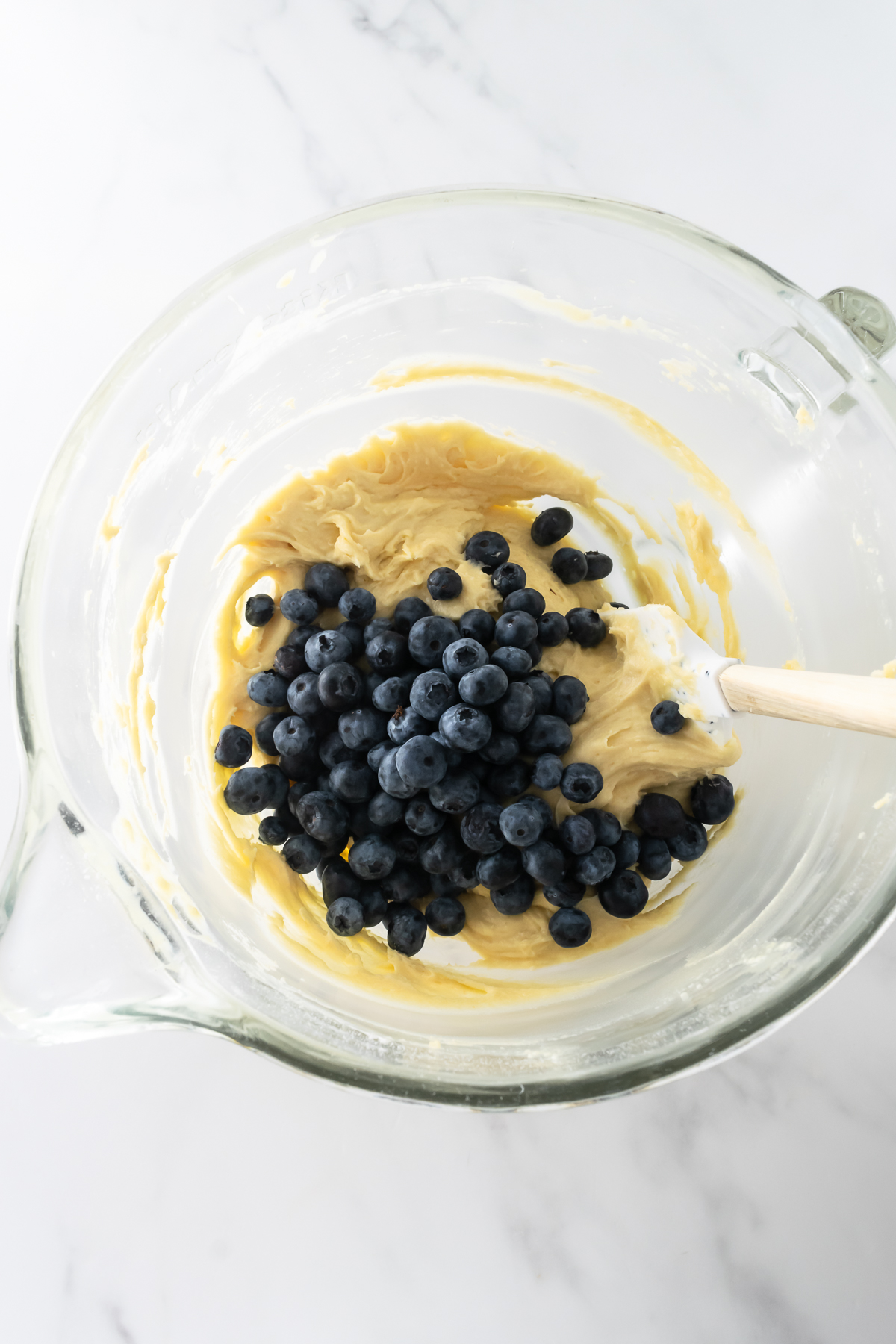 blueberry coffee cake batter with blueberries in a mixing bowl.