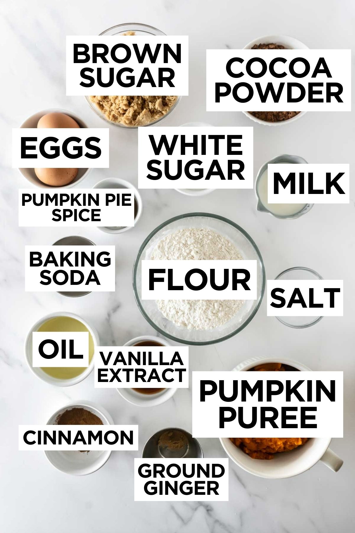 ingredients for pumpkin chocolate muffins in bowls on a white table.