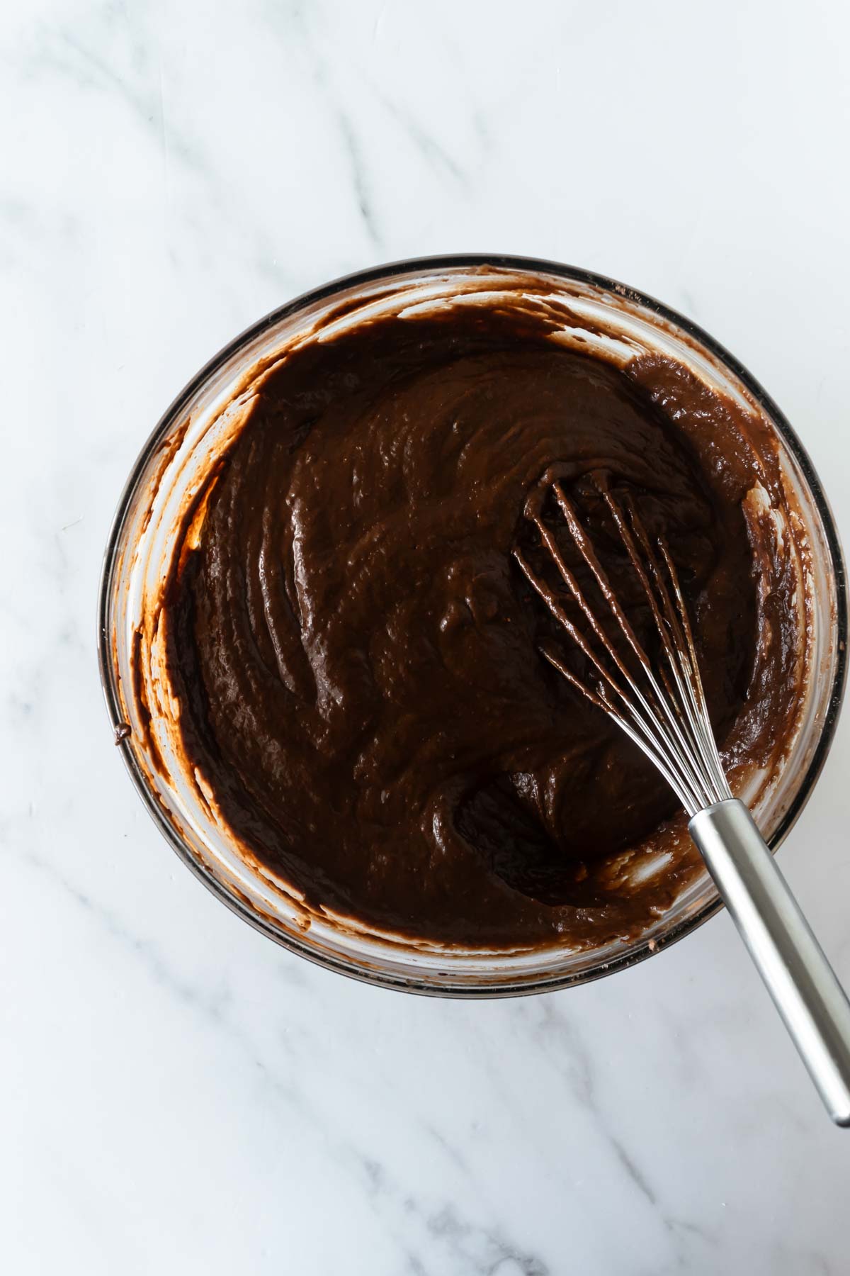 chocolate pumpkin muffin batter in a bowl with a whisk.