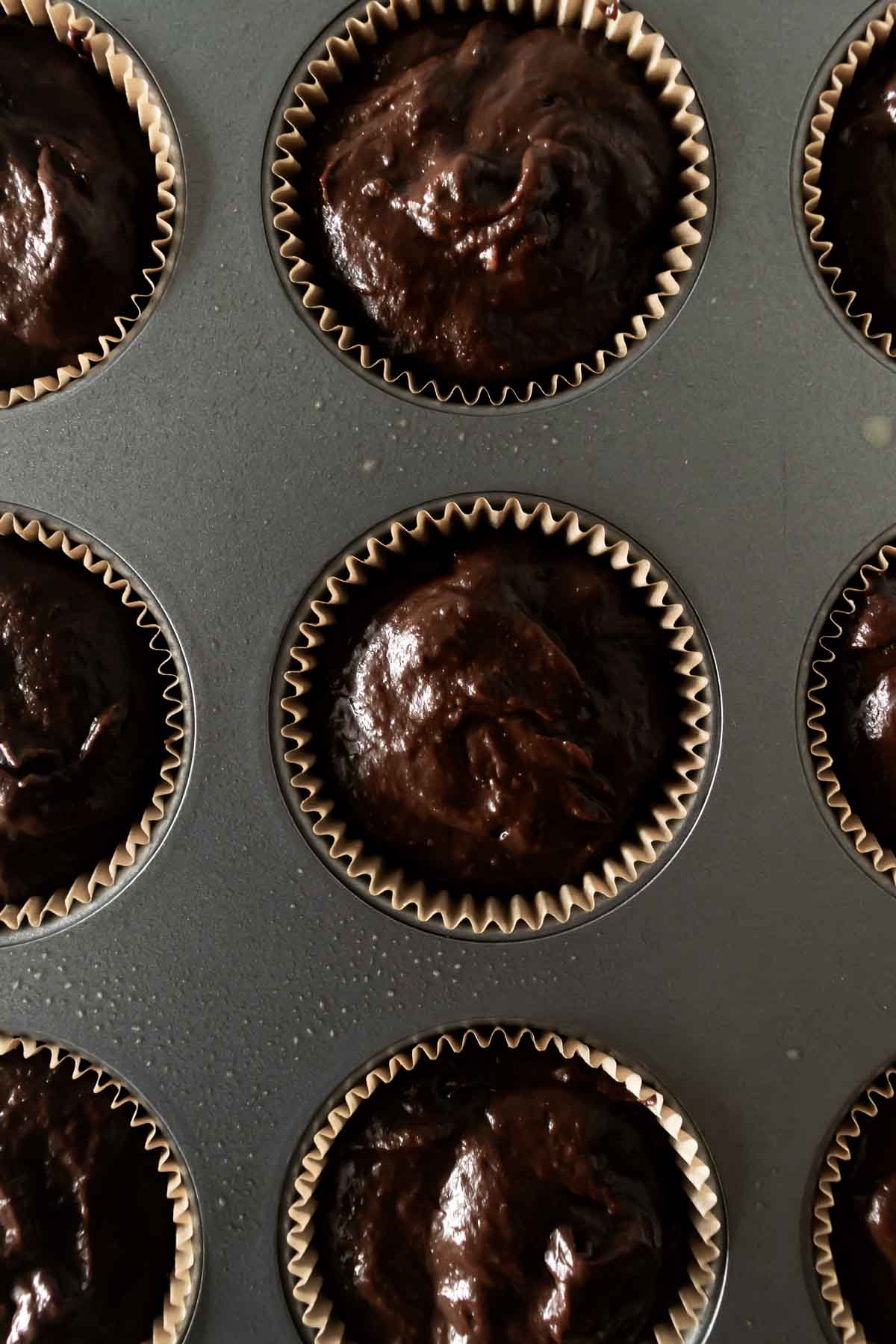 chocolate pumpkin muffin batter in a muffin pan.