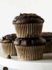 stacked pumpkin chocolate muffins on a marble board.