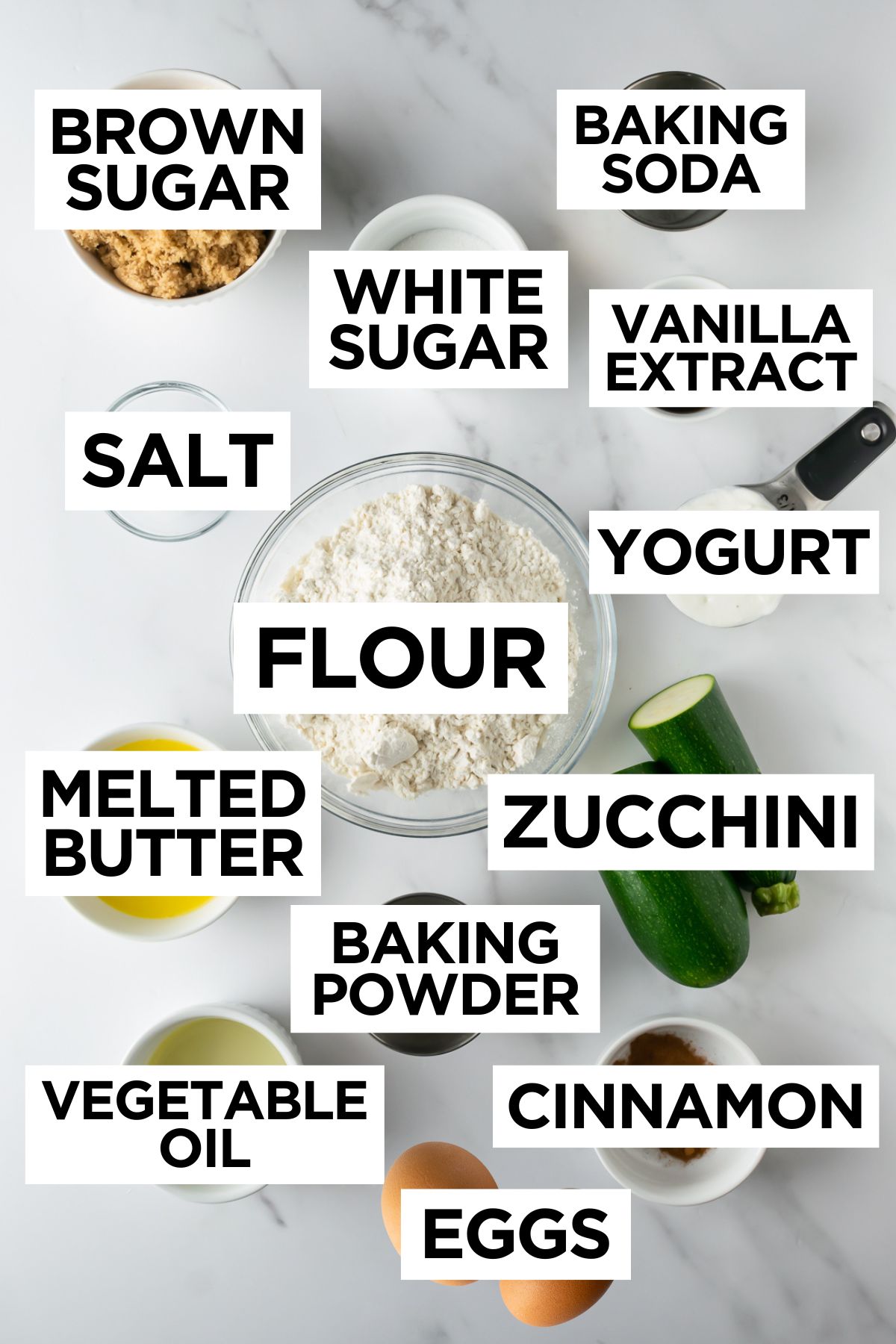 ingredients for homemade zucchini bread in bowls on a white table with overlay text.