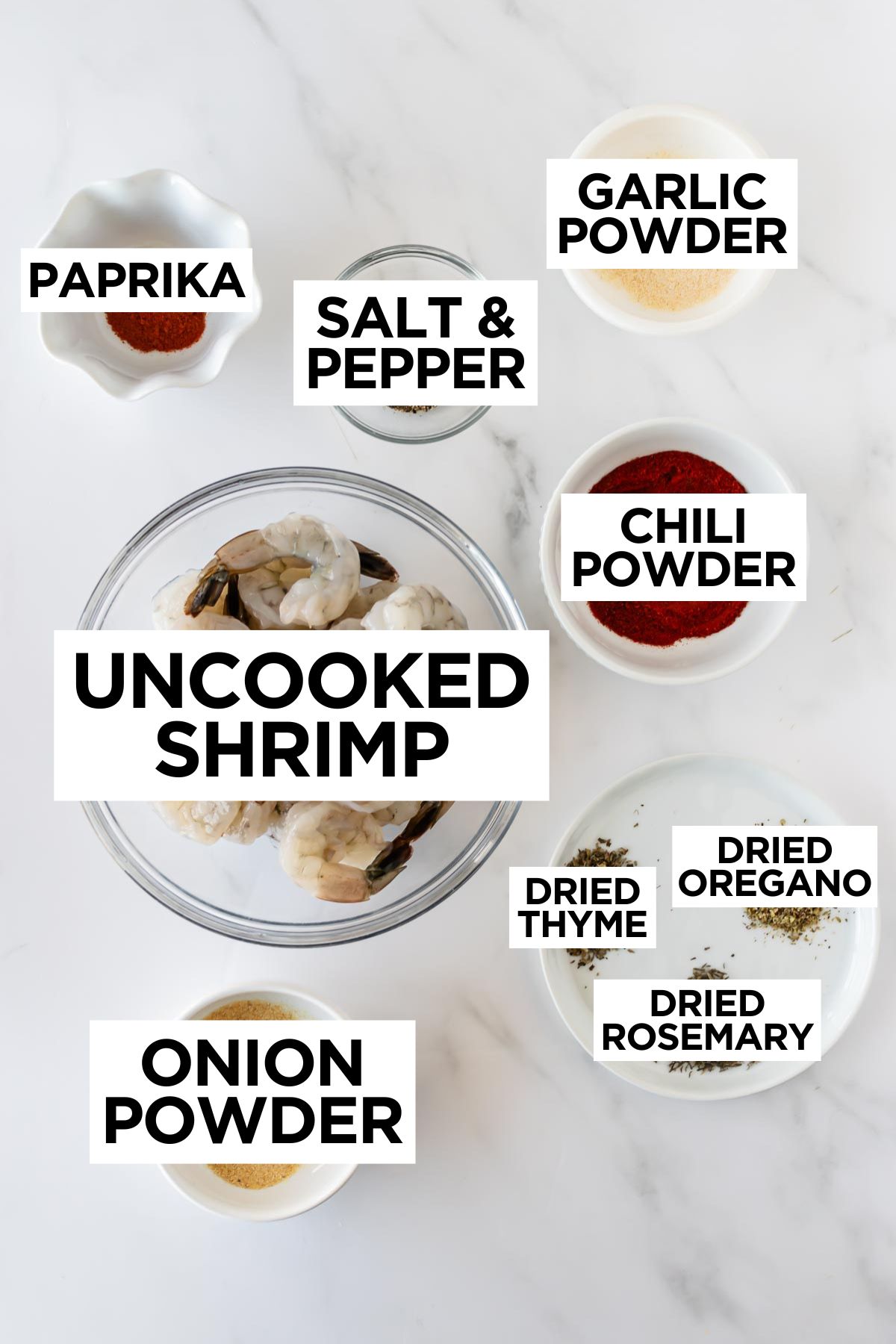 ingredients for blackened shrimp in bowls on a white table.