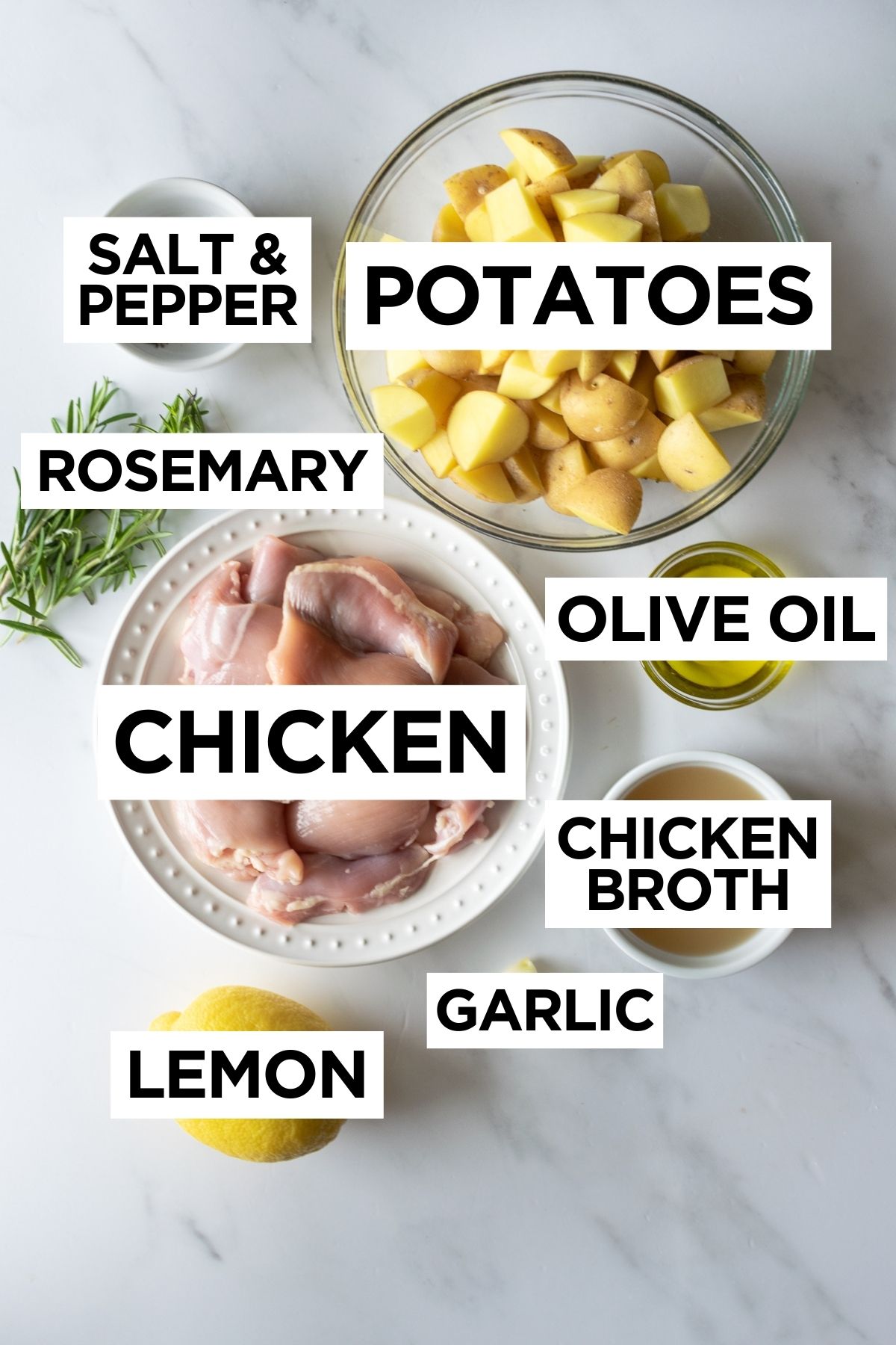 ingredients for lemon rosemary chicken in bowls on a white table.