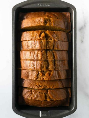 slices of baked pumpkin bread in a loaf pan.