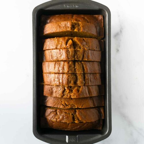 slices of baked pumpkin bread in a loaf pan.